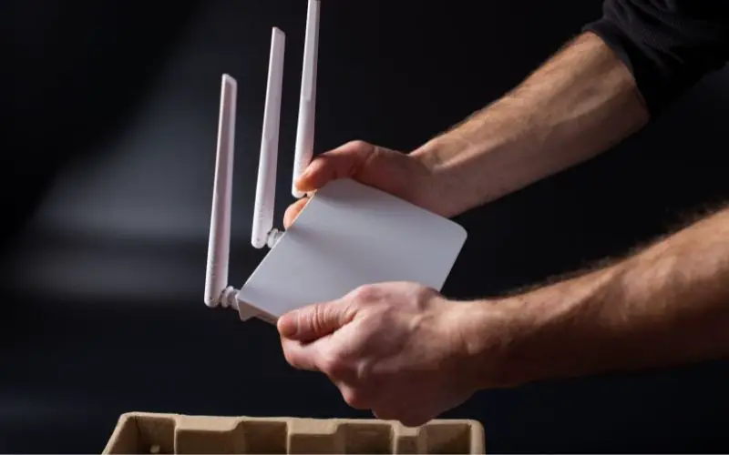 Unpacking new router. White router in hands. Connecting wifi router to network